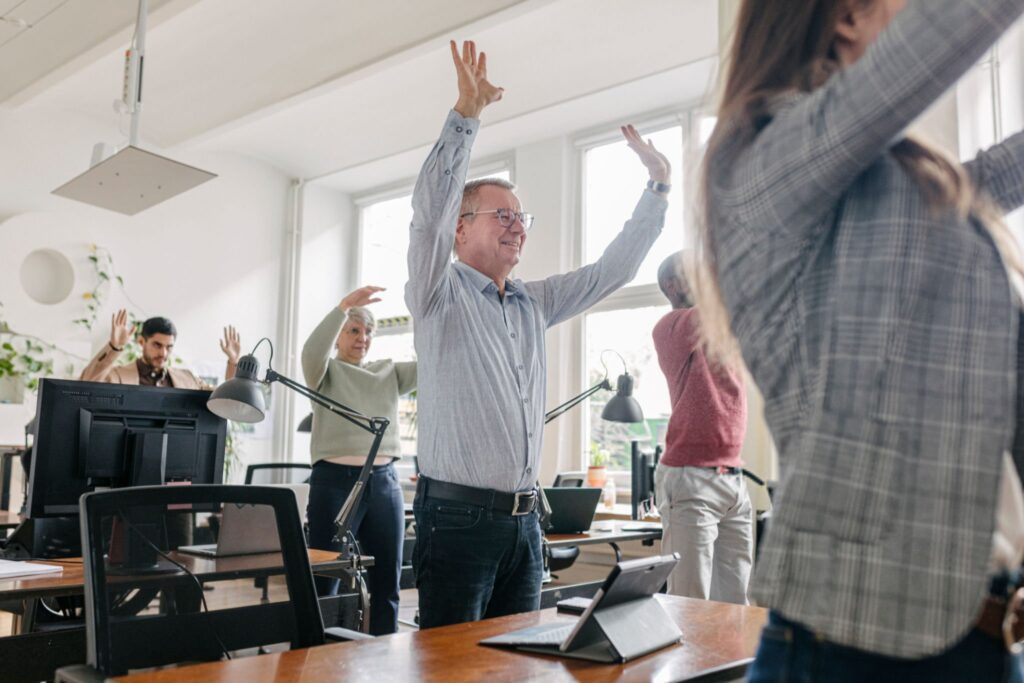 colleghi di lavoro fanno pausa esercizi per avere più energia 