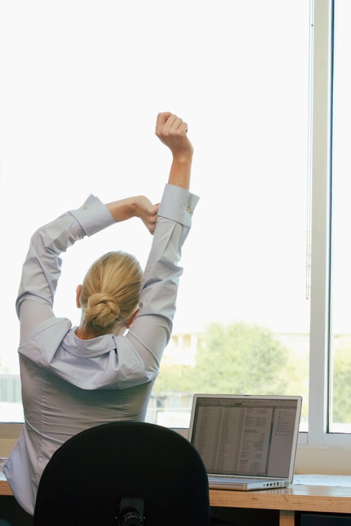 donna fa esercizi in ufficio di postura per prevenire dolori alla schiena  