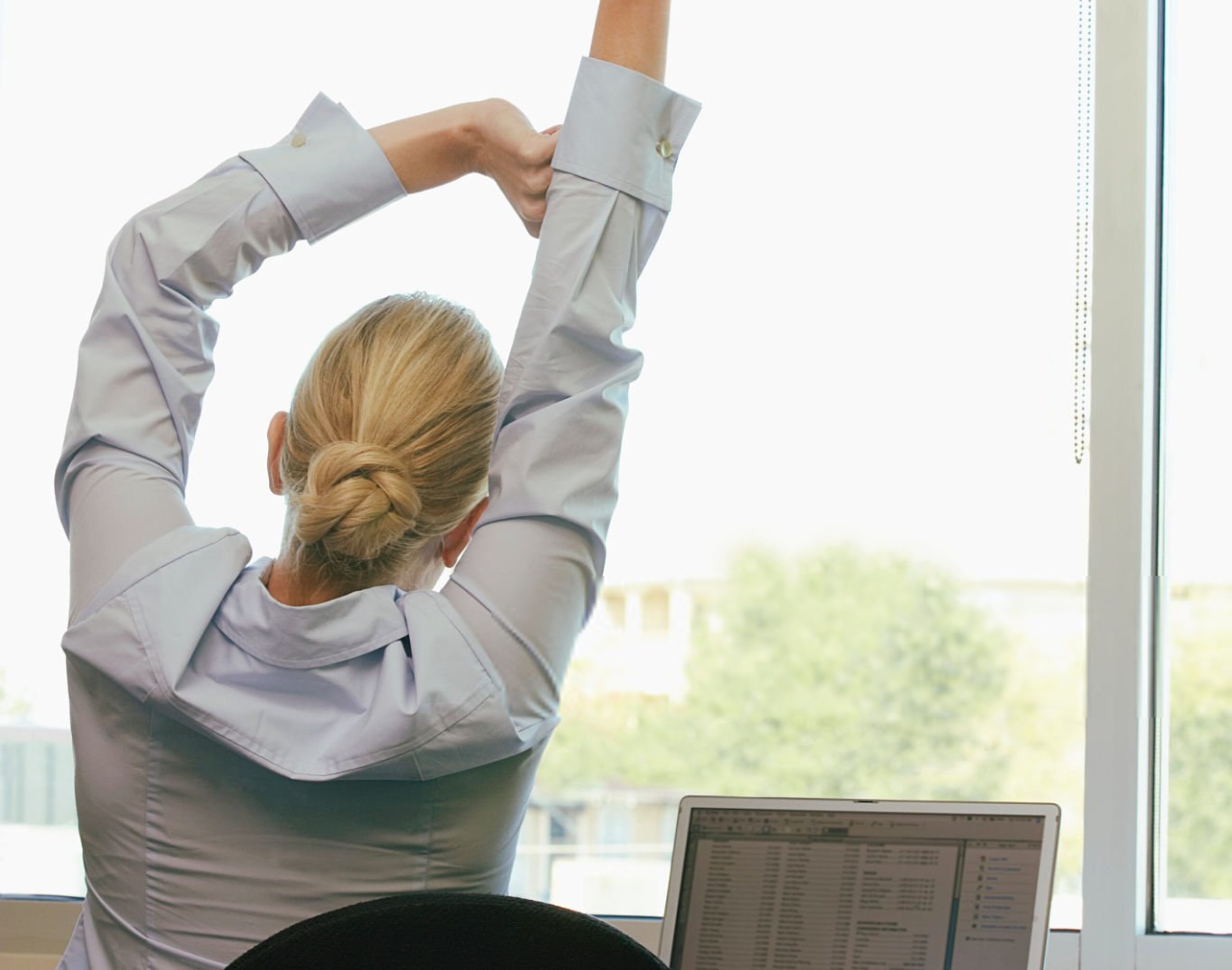 donna fa esercizi quotidiani alla scrivania per prevenire mal di schiena